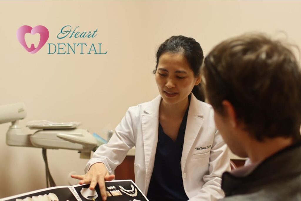 Dr. Thu Tran, dental implant dentist in Carson, explaining to patients about the  treatment.